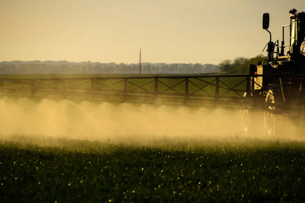 拖拉机喷雾器的液体肥料喷射 拖拉机在喷雾器的帮助下 在田里的幼小麦上喷洒液体肥料 使用精细分散的喷雾化学品 — 图库照片