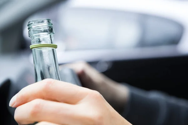 司机和喝酒的特写 年轻女子开车用一瓶酒不喝酒和驾驶的概念 驾驶的影响 — 图库照片