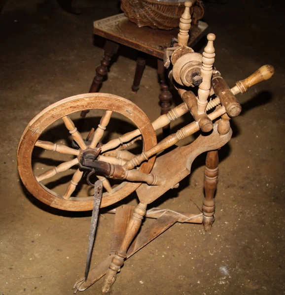 An old wooden spinning wheel was spun on the wool