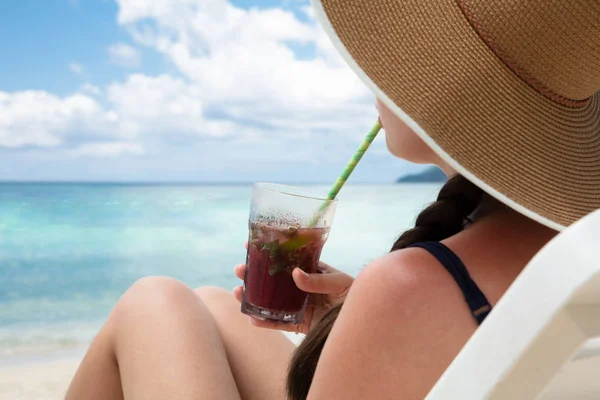 Woman Sitting Deck Chair Wearing Hat Drinking Juice Straw Beach — 스톡 사진
