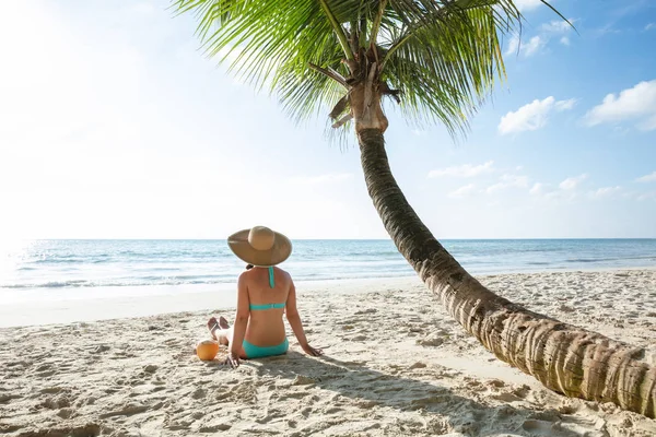 해변에 모래에 코코넛 모자를 여자의 뒷모습 — 스톡 사진