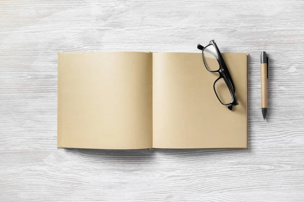 Aufgeschlagenes Buch Mit Leeren Bastelpapierseiten Stift Und Brille Auf Hellem — Stockfoto