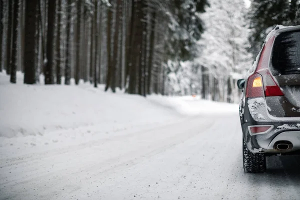 森の中の雪に覆われた冬の道の車 雪を乗り越えるためにその4輪駆動能力を使用して — ストック写真