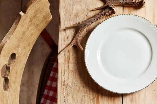 Κενό Λευκό Πιάτο Κέρατα Ελαφιού Ένα Ρουστίκ Τραπέζι Πεύκου Κενή — Φωτογραφία Αρχείου