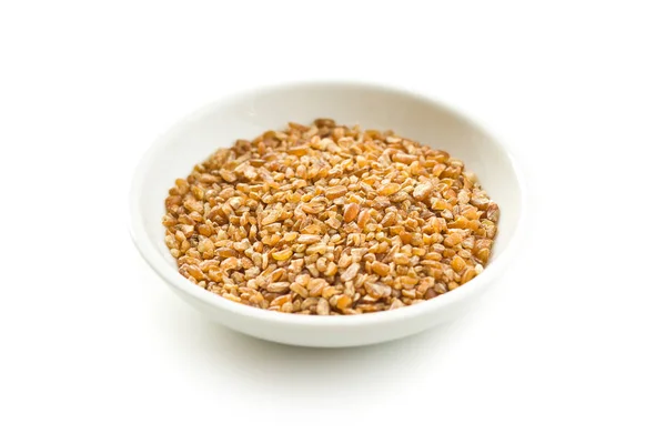 白い背景に隔離されたボウルに乾燥ブルグル小麦粒 — ストック写真