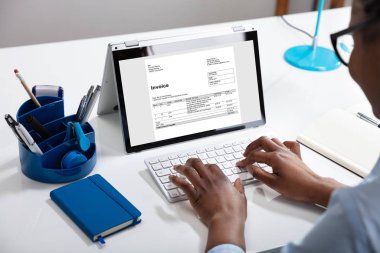 Close-up Of Businesswoman Using Digital Laptop Preparing Invoice clipart