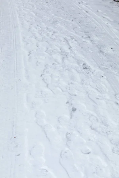 Foot prints of human shoes on the white snow