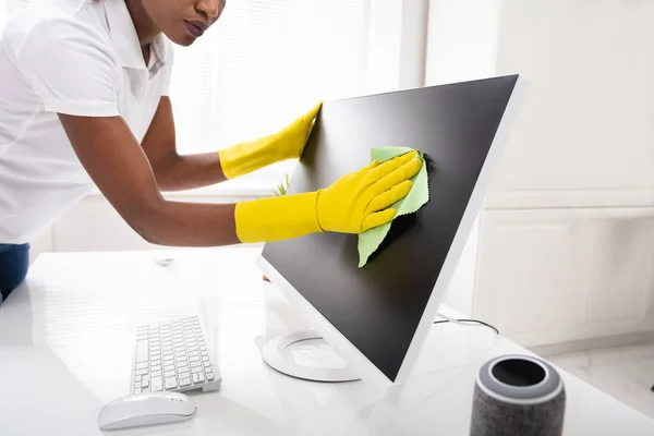 妇女用绿色抹布在办公室里清洁桌面屏风的特写 — 图库照片