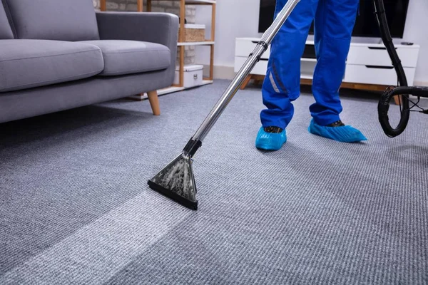 Bagian Rendah Dari Male Janitor Membersihkan Karpet Dengan Vacuum Membersihkan — Stok Foto