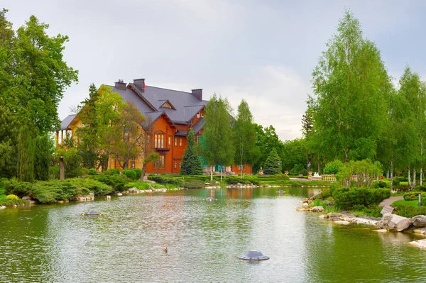 Large wooden house and pond in front. Mezhyhirya, Kiev, Ukraine