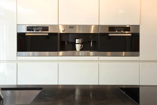 精致而现代的白色厨房内部 配有烤箱和咖啡机 内部清洁豪华 — 图库照片