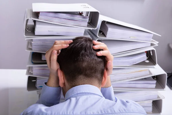 Rear View Stressed Businessman Hand Head Front Stacked Folders Stock Photo