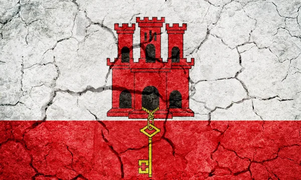 Gibraltar flag on dry earth ground texture background