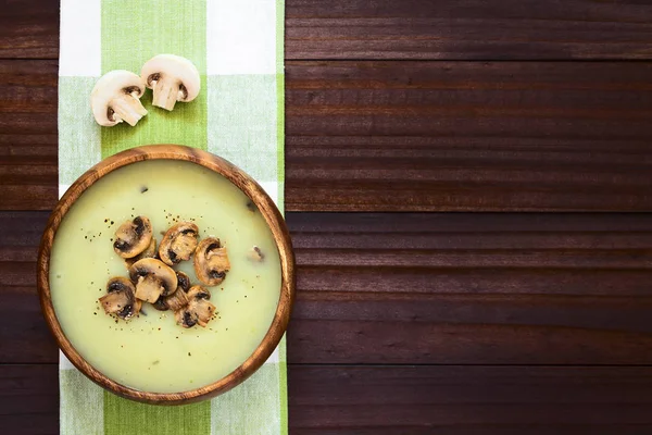 蘑菇奶油汤装饰着烤蘑菇片 洒上黑胡椒 放在木碗里 用自然光拍在头顶上 选择性聚焦 聚焦汤 — 图库照片