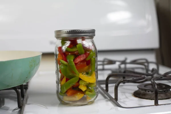 Glass Jar Filled Sliced Red Yellow Green Bell Peppers Stove — Stock Photo, Image