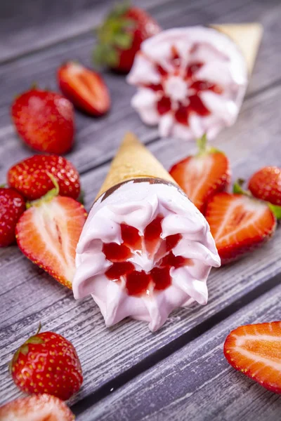 在古老的木制桌子上放着草莓的冰淇淋圆锥 以冰淇淋为重点 — 图库照片