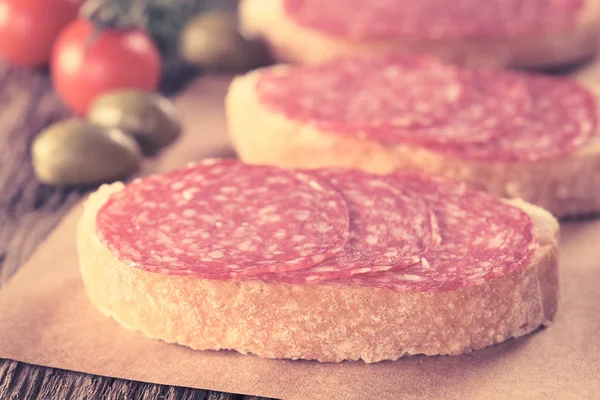 Fatias Salame Pão Ciabatta Com Azeitonas Verdes Tomate Cereja Parte — Fotografia de Stock