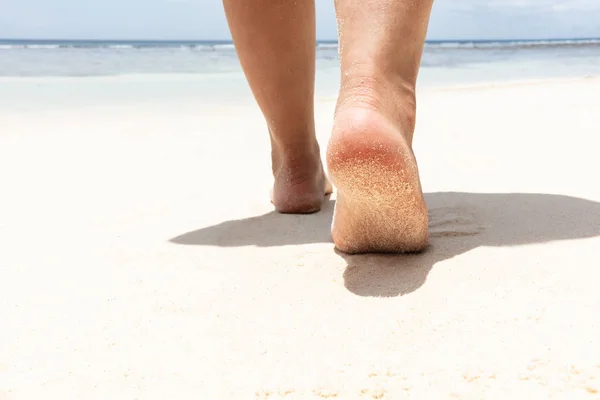 低段妇女的脚走在沙滩走向大海 — 图库照片