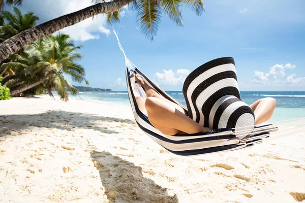 Mujer Con Sombrero Rayado Relajándose Hamaca Sobre Playa Idílica Verano —  Fotos de Stock