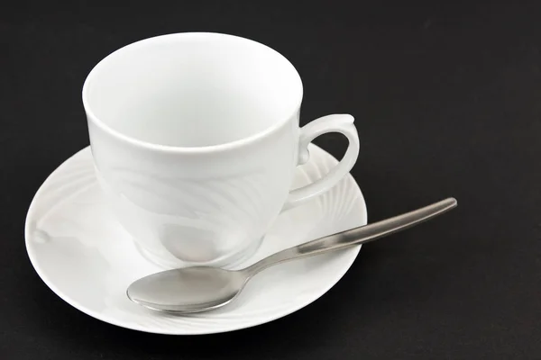 Siyah Arka Planda Çay Tabağı Kahve Kaşığı Olan Beyaz Kahve — Stok fotoğraf