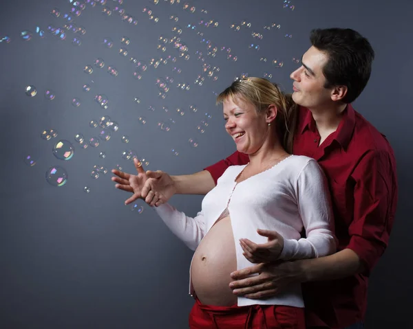 Šťastná Krásná Těhotná Žena Její Manžel Chytí Mýdlové Bubliny — Stock fotografie