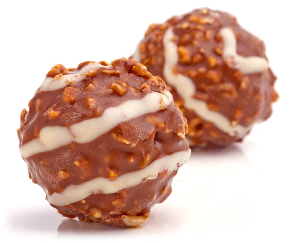 白い背景にヘーゼルナッツで満たされた甘いチョコレートボール — ストック写真