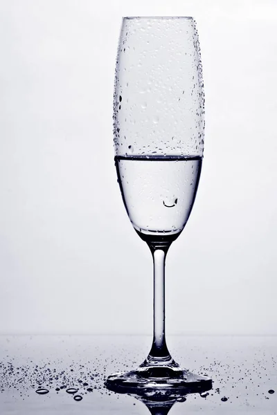 Бокал Влажного Шампанского Капельками Контрастирующими Белой Поверхностью Отражением Полу — стоковое фото