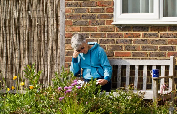Senior Vrouw Zittend Bench Lezing Tuin Zomer Zon — Stockfoto