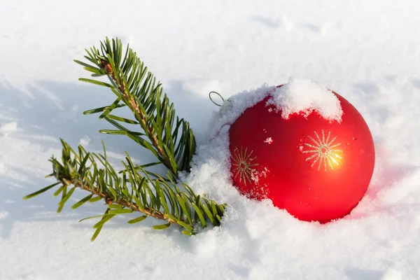 Κόκκινη Χριστουγεννιάτικη Μπάλα Σύμβολο Κλαδί Ελάτης Στο Χιόνι — Φωτογραφία Αρχείου