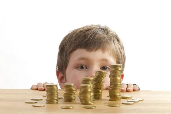 Boy Looks Money Towers Lying Table — Stock Photo, Image