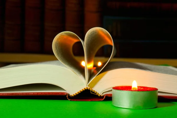 打开放在桌上放着燃烧的蜡烛的书 — 图库照片
