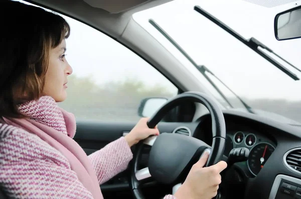 雨の中で車を運転する若いビジネス女性 顔に焦点を当てる — ストック写真