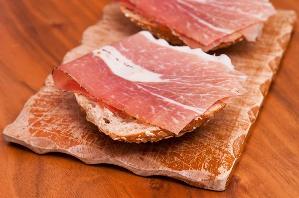Een Houten Bord Met Sandwiches Zijn Belegd Met Rauwe Ham — Stockfoto