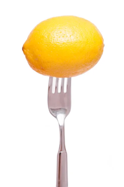 孤立した背景の前のフォークの上に黄色いレモンが — ストック写真
