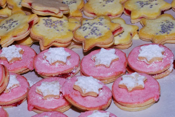 many pink biscuits with white sugar star on christmas