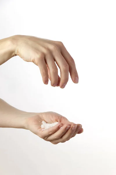 Händer Skingra Salt Mot Vit Bakgrund — Stockfoto