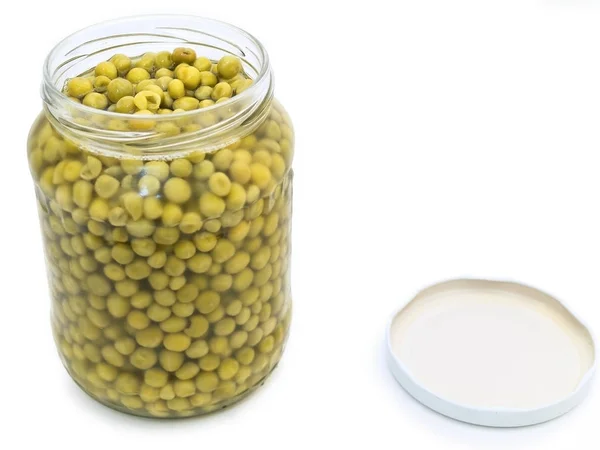 白いテーブルに緑のエンドウ豆の缶詰 — ストック写真