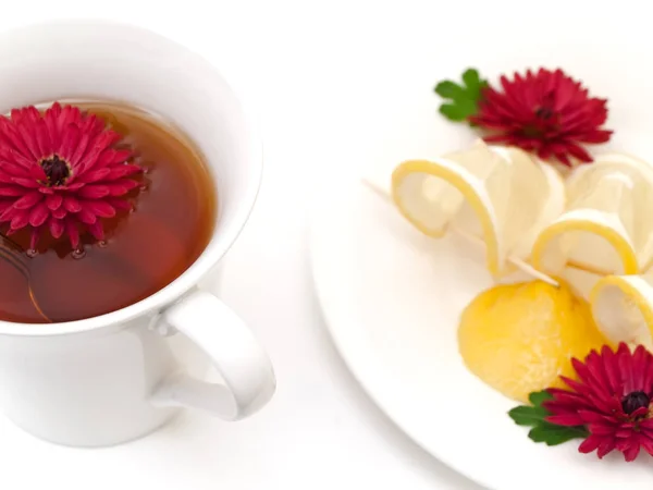 Tasse Tee Neben Dem Teller Mit Zitrone Und Blumen — Stockfoto