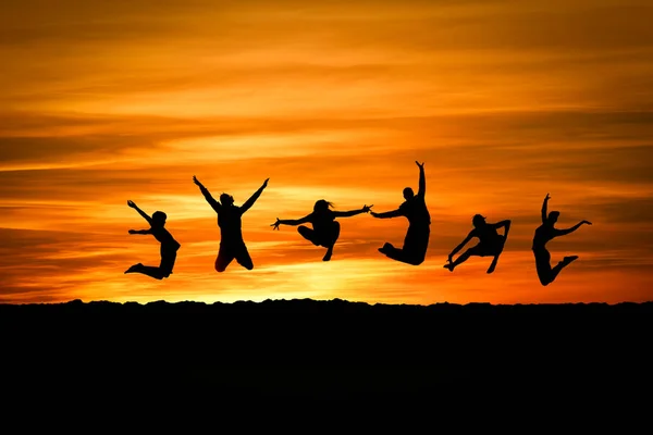 Silhouettes Jumping Sunset — Stock Photo, Image