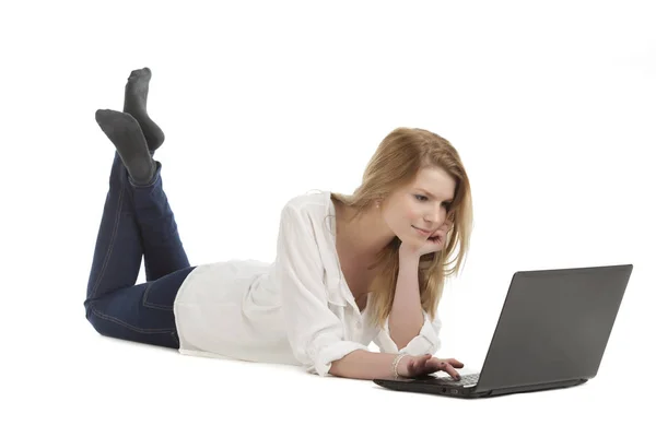 年轻的金发女人躺在电脑前 — 图库照片