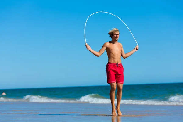 Νεαρός Άνδρας Πηδώντας Σχοινί Στην Παραλία — Φωτογραφία Αρχείου