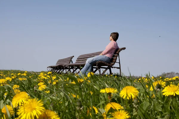 Młoda Kobieta Siedząca Trawie Kwiatami — Zdjęcie stockowe
