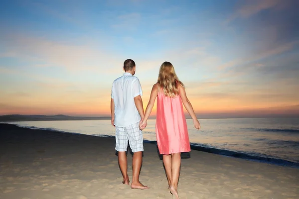日出时分在海滩散步的情侣 — 图库照片