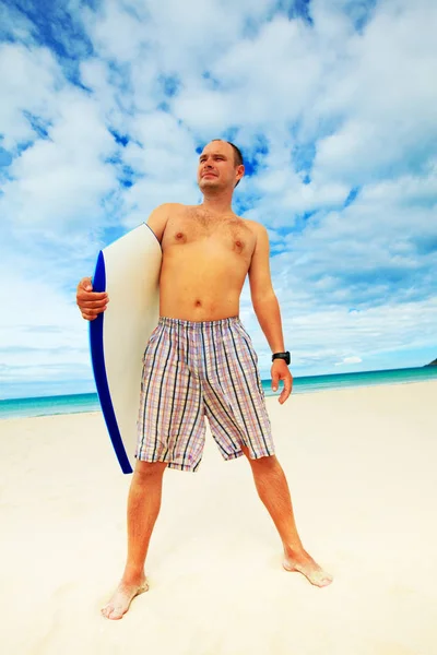 熱帯のビーチでボディー ボードを持つ男 — ストック写真