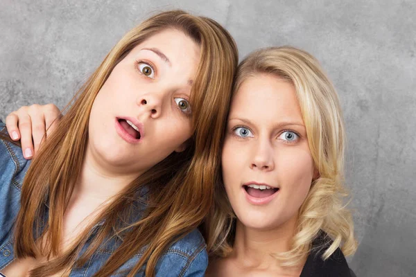 Két Meglepett Tinédzser Lány Portréja Vicces Stúdió Lövés Ellen Szürke — Stock Fotó