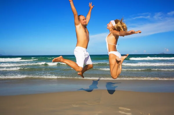 Молодая Пара Прыгает Тропическому Пляжу — стоковое фото