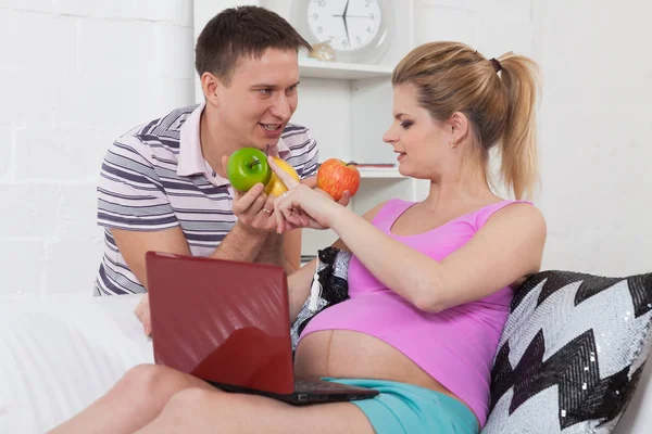 Feliz Familia Embarazada Con Frutas Sentarse Sofá Casa —  Fotos de Stock