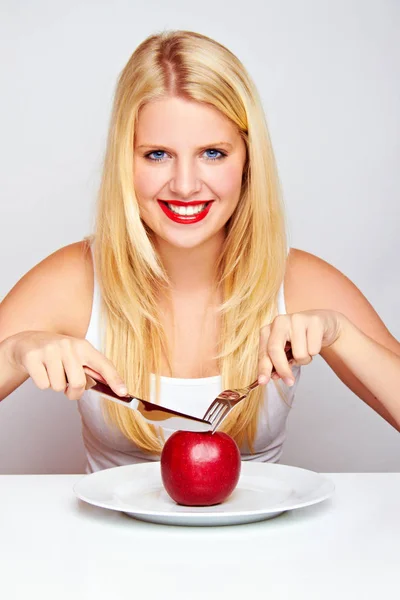 幸せな若い女性は刃物で果物を食べる — ストック写真