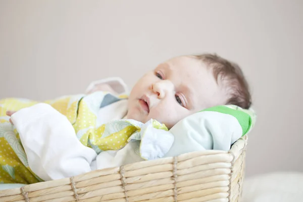 かわいいドレスに身を包んだバスケットで横になっているかわいい新生児の赤ちゃんの肖像画 — ストック写真