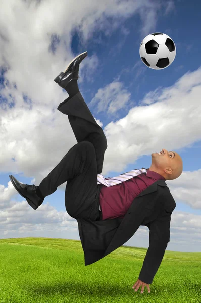 Бизнесмен Акробатической Позе Пинает Футбольный Мяч Зеленом Поле — стоковое фото